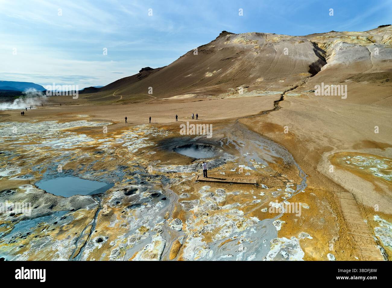 Hverir, Island. Touristen spazieren durch einzigartige geothermische Merkmale, einschließlich sprudelnder Schlammgruben und lebendiger Mineralienfelder an einer natürlichen Stätte in Island Stockfoto