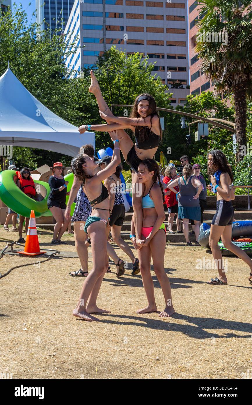 The Big Float, Portland, Oregon – 14. Juli 2018: Drei Mädchen werden bei Akrobatik gesehen, wobei ein Mädchen von den anderen beiden aufgehalten wird. Stockfoto