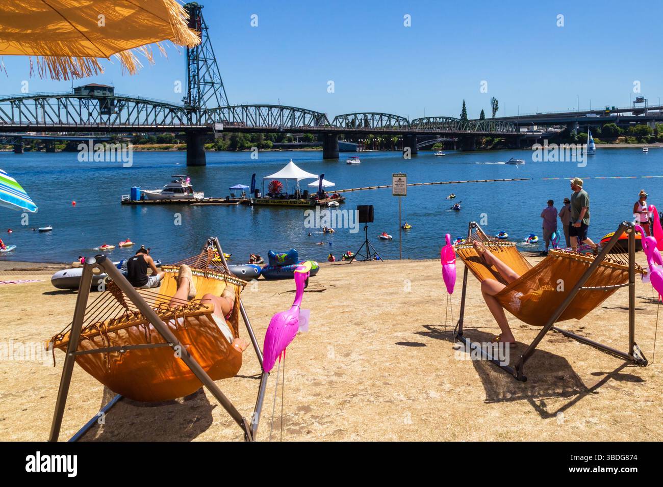 The Big Float, Portland, Oregon - 14. Juli 2018: Menschen entspannen sich in Hängematten am Strand, während andere während der jährlichen Veranstaltung im Willamette River schwimmen Stockfoto