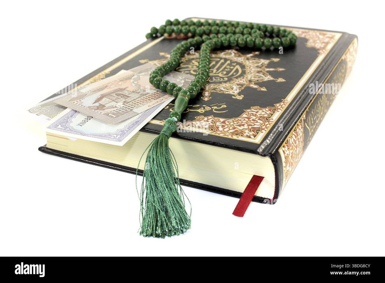 Geschlossener Koran mit pakistanischer Währung vor hellem Hintergrund Stockfoto
