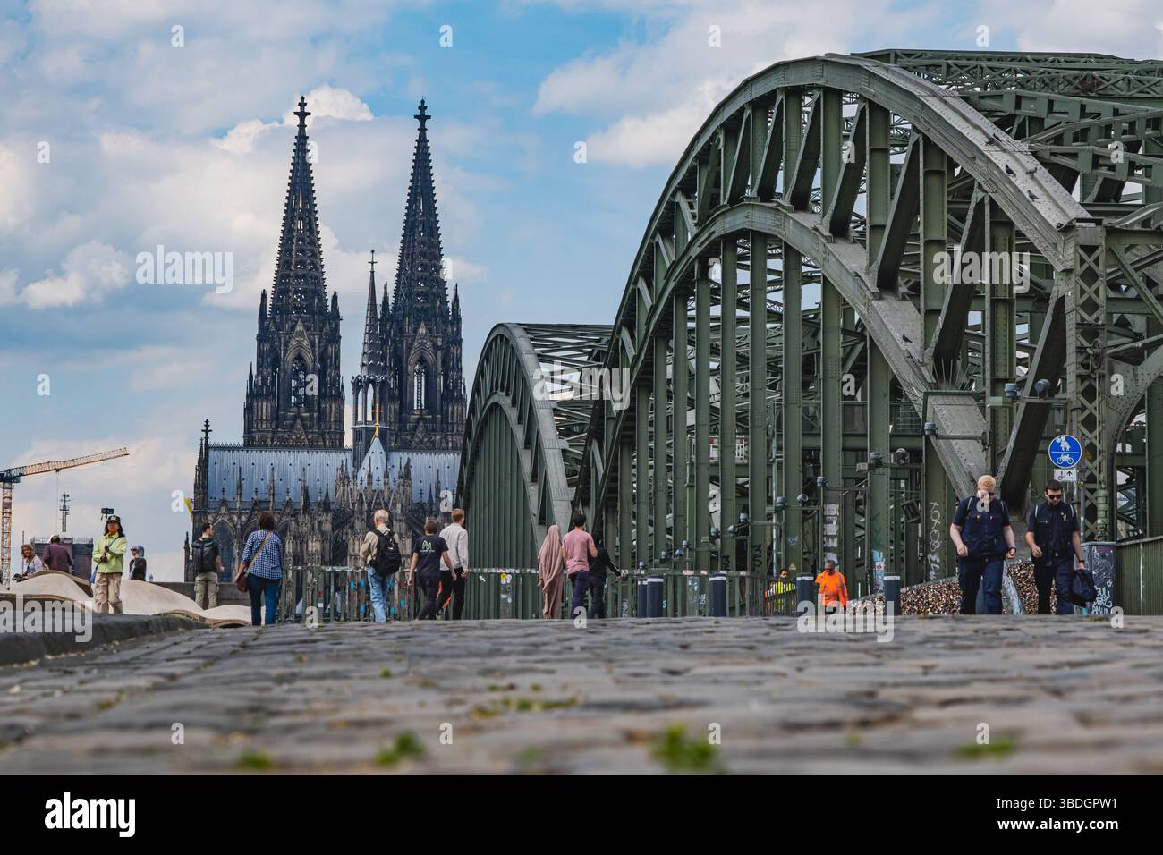 Touristen sehen den Kölner Dom und die Hohenzollernbrücke daneben Stockfoto