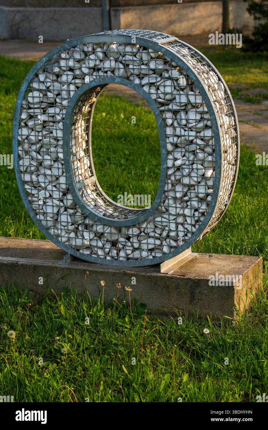 Buchstabe O – Metallrahmen mit Sonnenlicht gefüllt mit weißen Kieseln Stockfoto