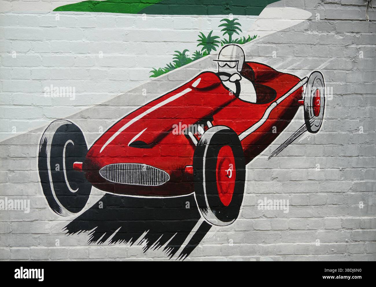Künstlerisches Fototapete mit einem roten Rennwagen mit einem malerischen Hintergrund. Kunst von Mason, Dorking, Großbritannien Stockfoto