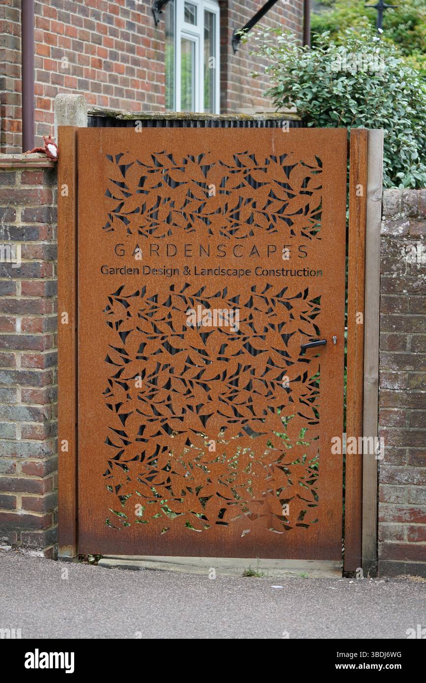 Verziertes rostetes Metalltor mit modernem Design im Garten. Dorking, Großbritannien Stockfoto