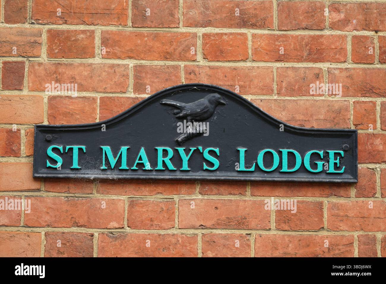 St. Mary's Lodge Schild auf einer Ziegelmauer mit Vogelmotiv. Dorking, Großbritannien Stockfoto