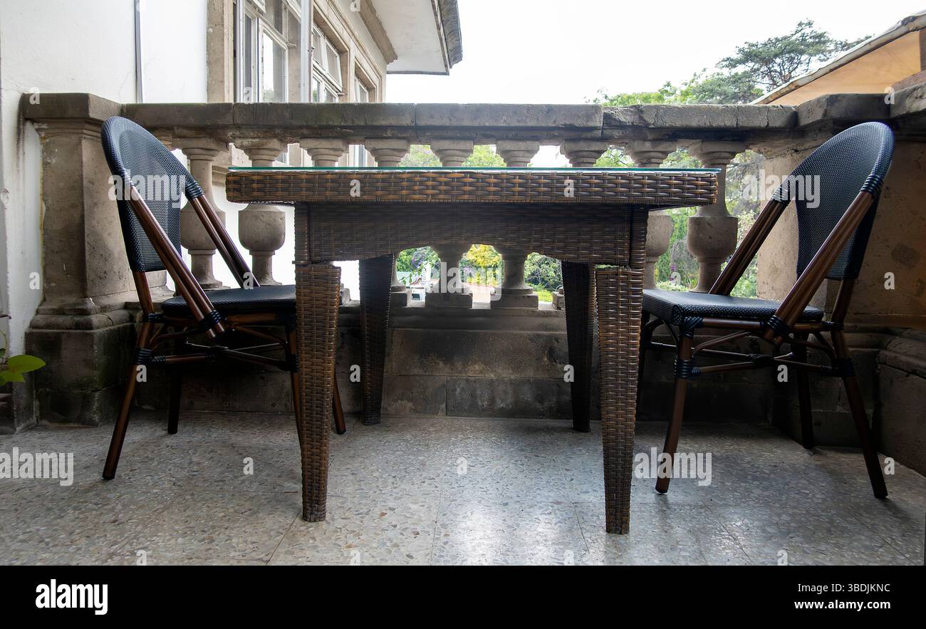 Tisch, zwei Stühle, keine Leute auf der Balkonterrasse Stockfoto