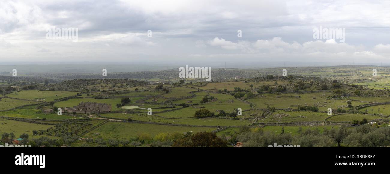Eine Panorama-Landschaft Blick auf alte Felswände und Felder in der Eichenlandschaft von Extremadura Stockfoto