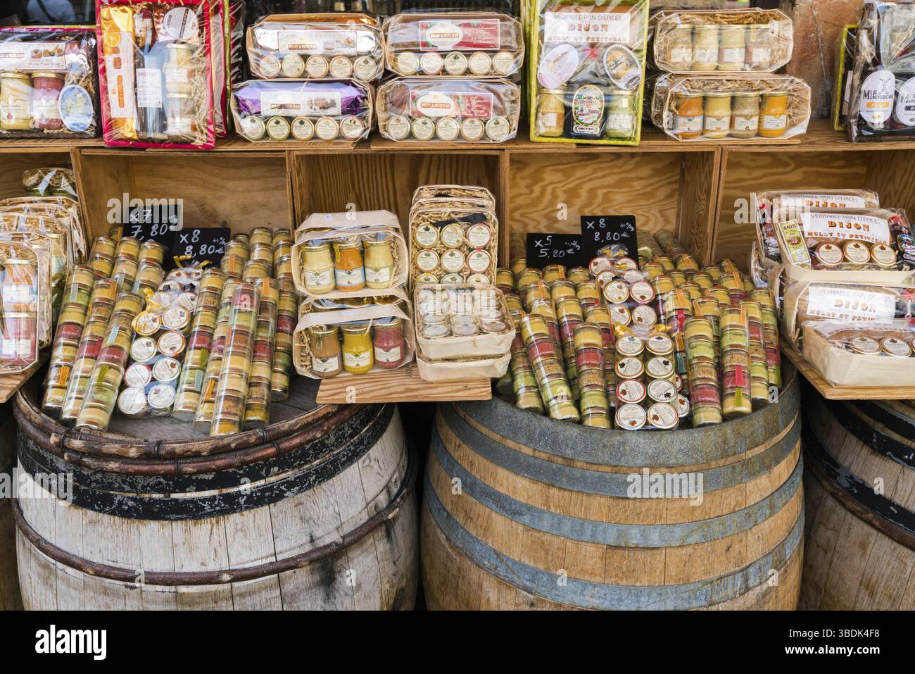 Aus der Nähe zu sehen. viele verschiedene Arten von Dijon Senf in den Regalen und alten Weinfässern Stockfoto