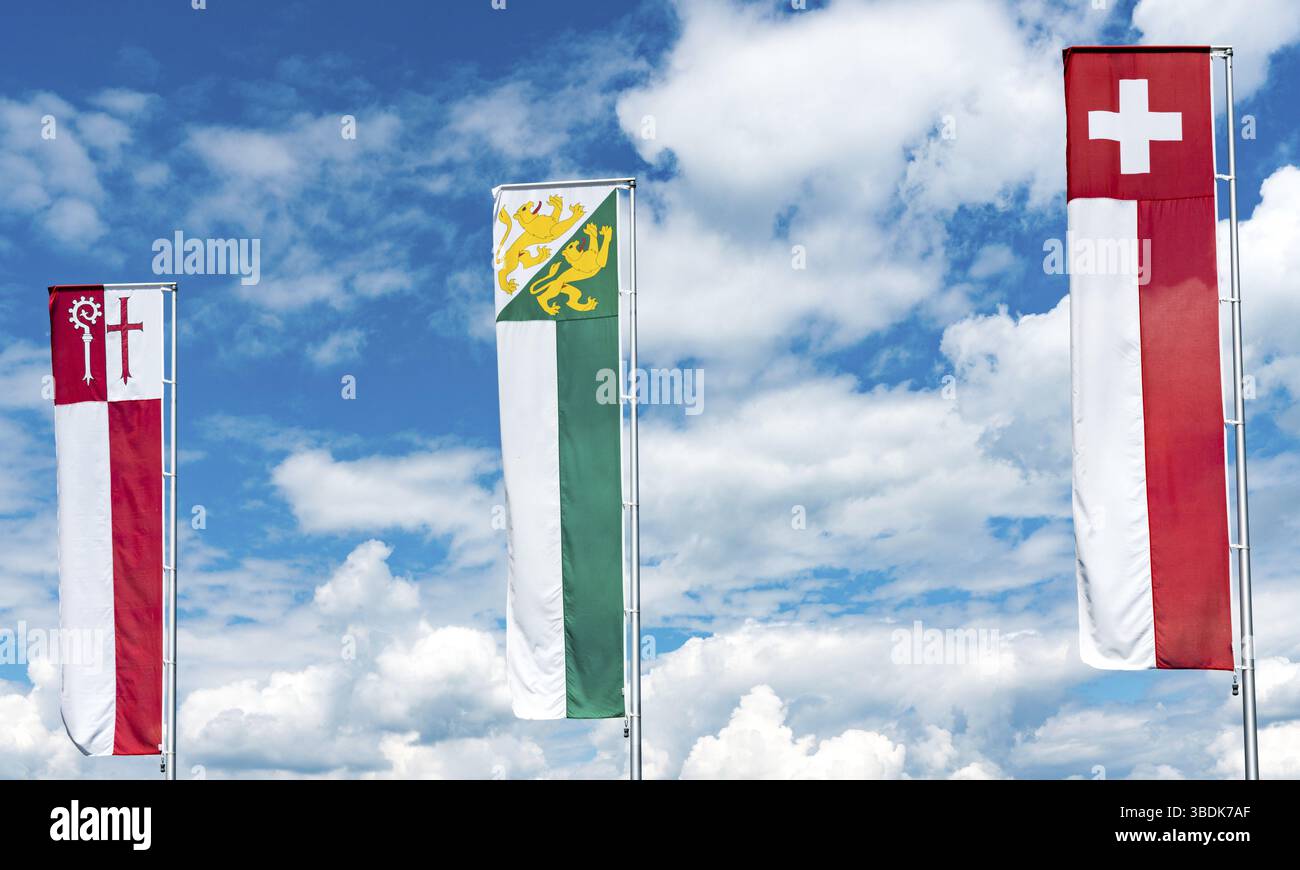 Horizontale Ansicht von Flaggen und Fahnen der Schweiz und Thurgau und Kreuzlingen unter einem ausdrucksvollen blauen Himmel mit weißen Wolken Stockfoto