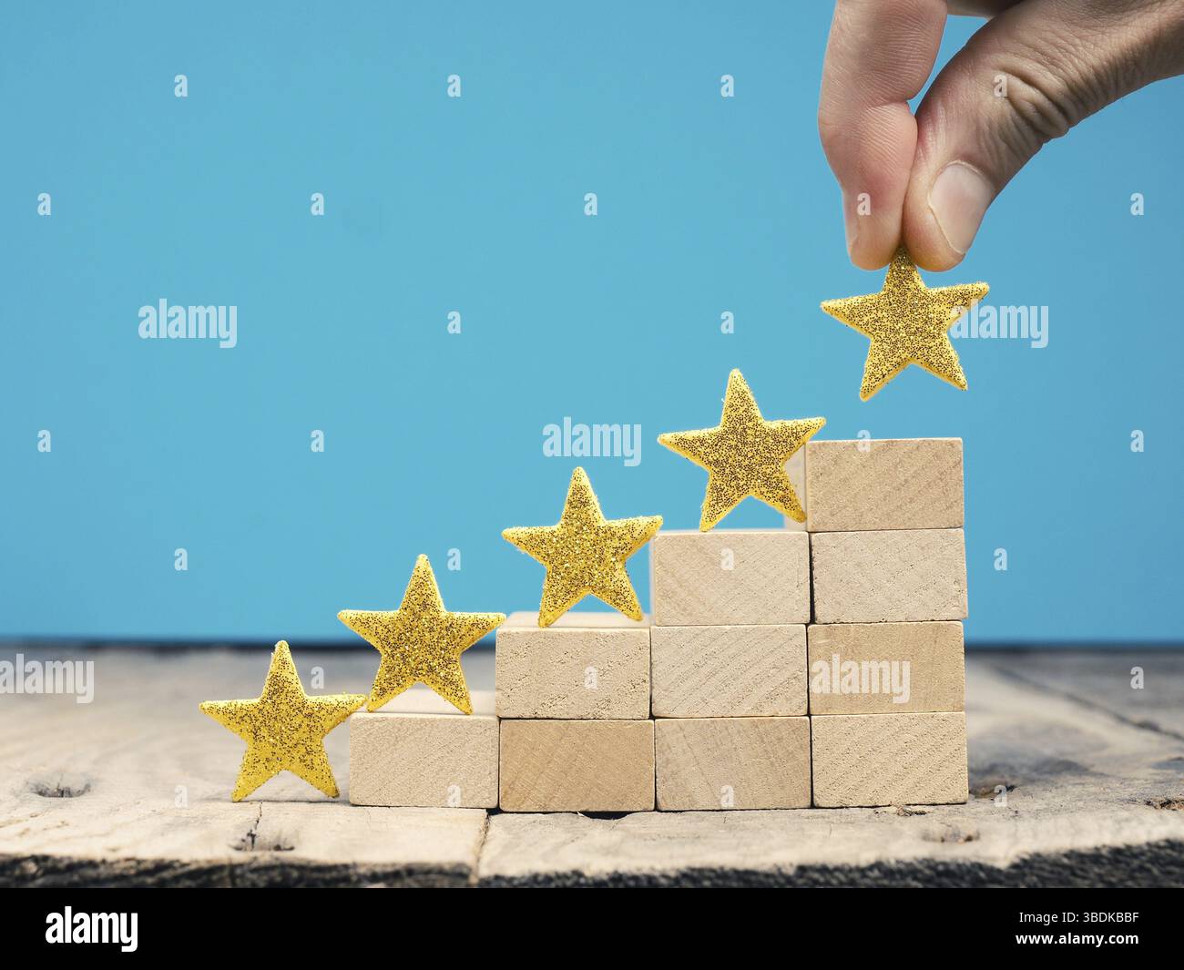 Geschäftsmann mit einer großen Goldenen Stern, Bewertung oder Ranking System Konzept mit hölzernen Treppen Stockfoto