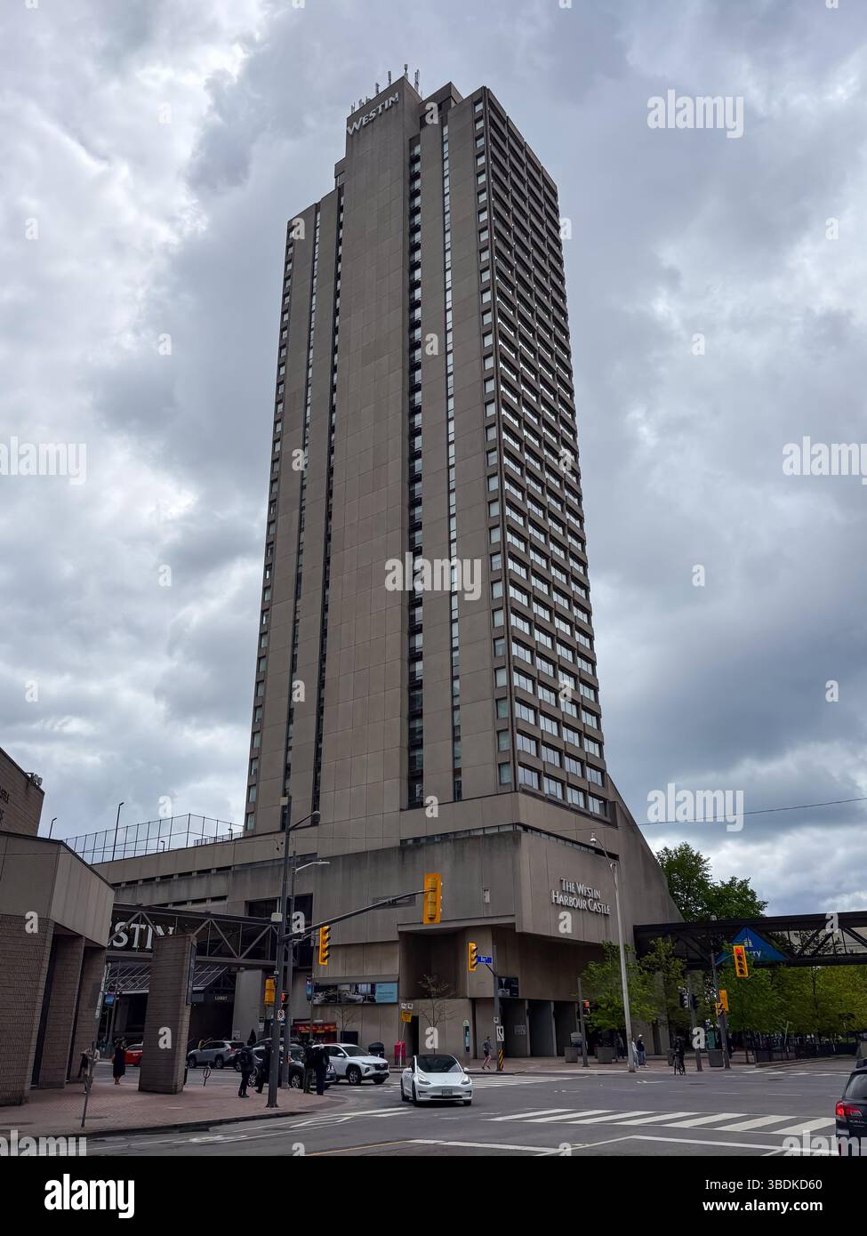 Das Westin Harbour Castle. Hohes Betongebäude mit vielen Fenstern vor bewölktem Himmel in Toronto, Kanada. Blick auf Straßenebene einschließlich Autos und Fußgänger Stockfoto