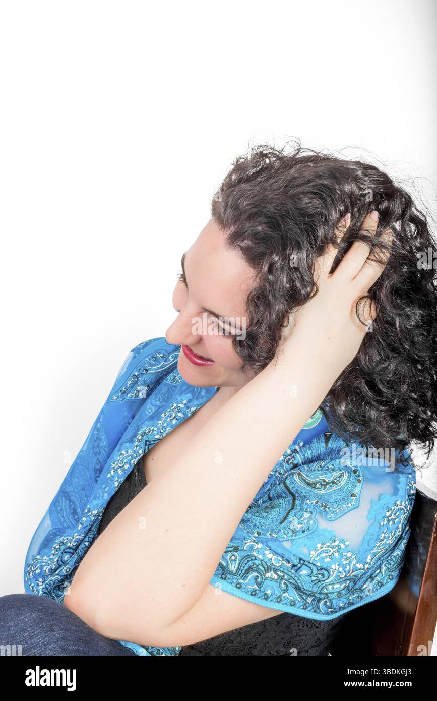 Ein junges Model, Mitte 20, trug aquafarbene Ohrringe im nahöstlichen Design und einen blauen Schal Stockfoto