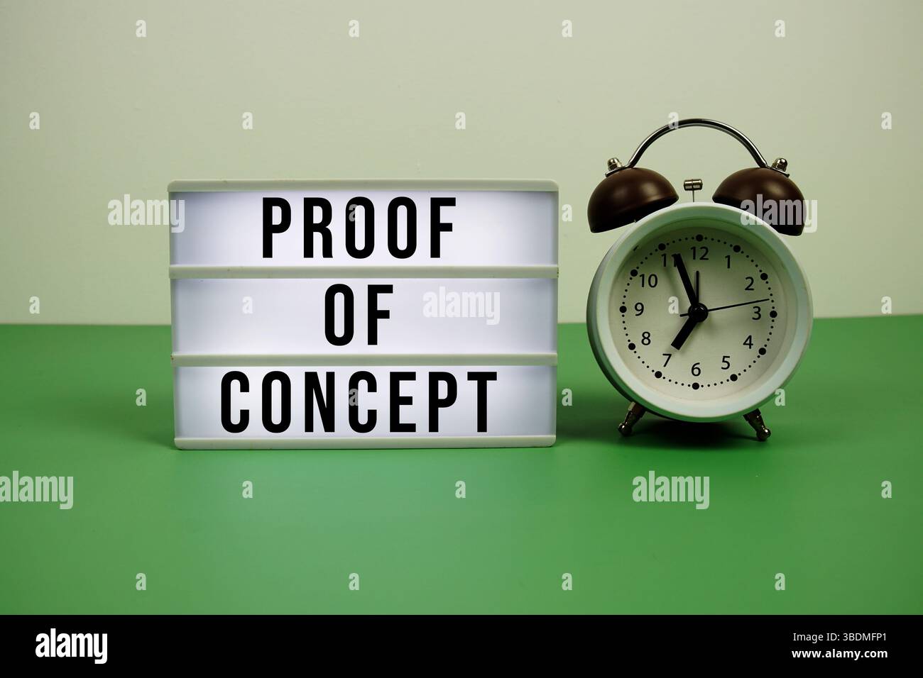 Proof-of-Concept-Text auf LED-Leuchtkasten mit Wecker auf grünem Hintergrund Stockfoto