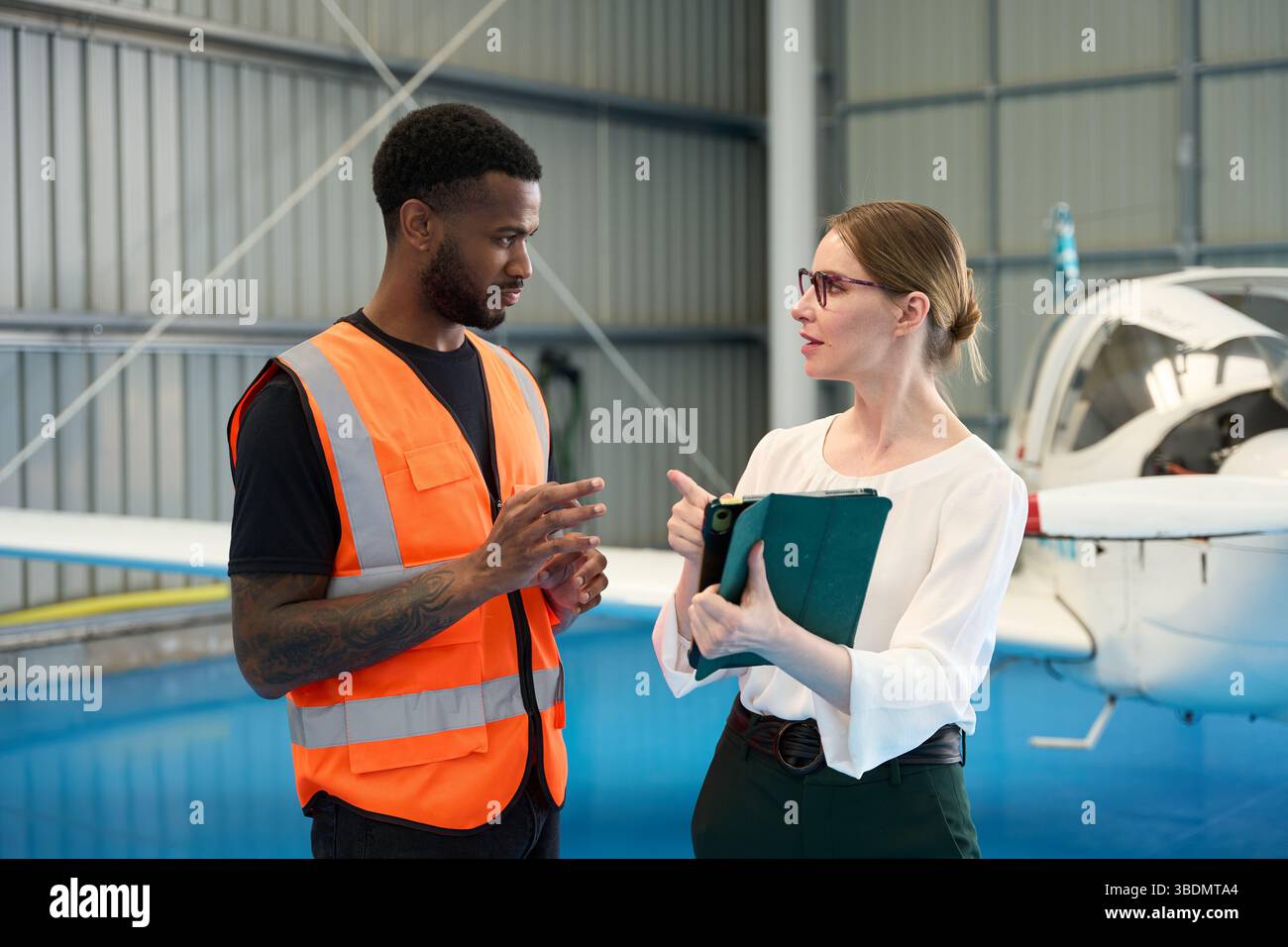 Flugzeugwartungslehrer, der den Schüler im Hangar führt Stockfoto