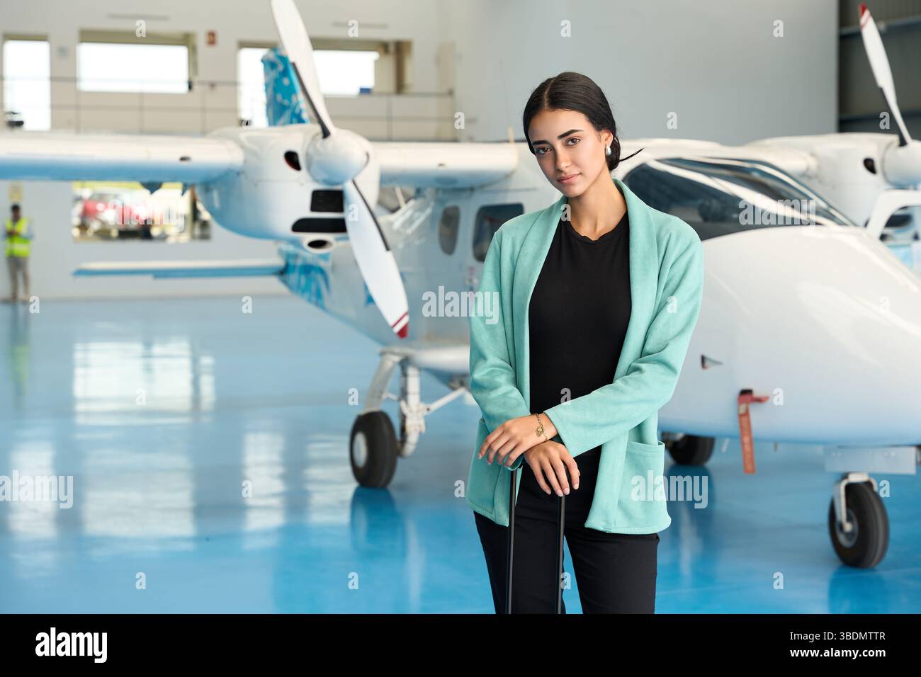 Selbstbewusster Flugzeugwartungstechniker, der sich im Hangar mit einem kleinen Flugzeug ausgibt Stockfoto