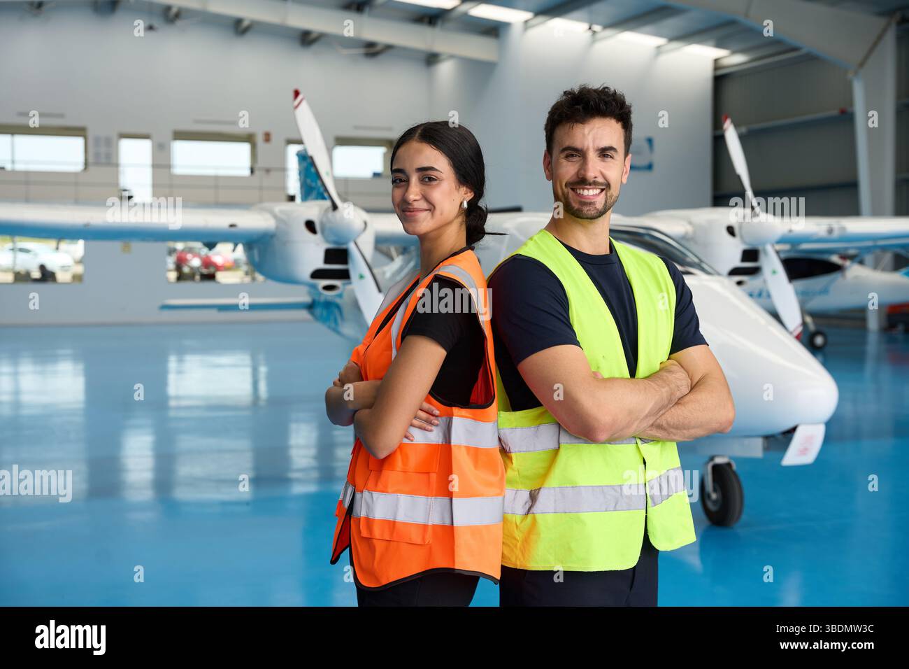 Flugzeugwartungstechniker lächeln im Hangar mit leichten Flugzeugen Stockfoto