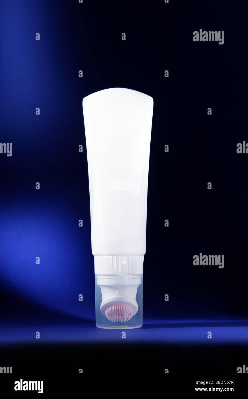 Reinigungsmittel. Eine weiße Flasche auf dunkelblauem Hintergrund. Modell. Werbefoto von Kosmetika. Stockfoto