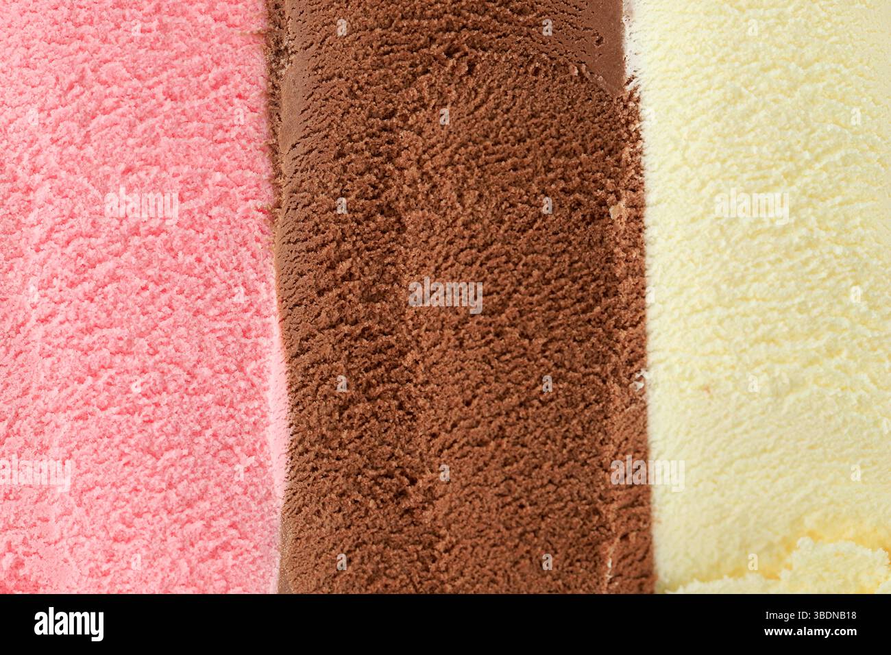 Textur von rosa, weiß und Schokoladeneis wie Hintergrund, Nahaufnahme neapolitanisches Eis Stockfoto