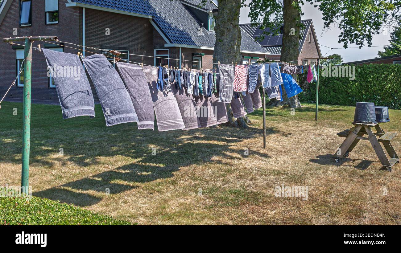 Die Handtücher, Geschirrtücher und Socken, die mit Stiften gesichert sind, trocknen an der Wäschelinie, Provinz Friesland, Niederlande Stockfoto