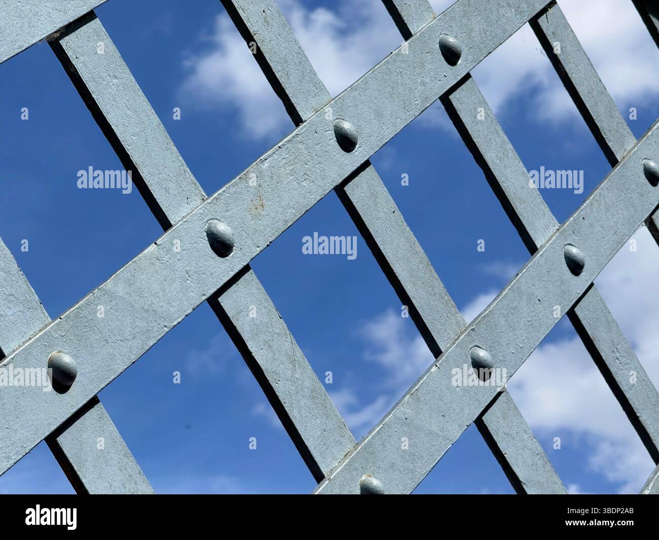 Detail der Metallkreuzschraffur an der Seite der Dobson-Brücke mit blauem Himmel im Hintergrund. Queen's Park im Stadtzentrum von Bolton Stockfoto