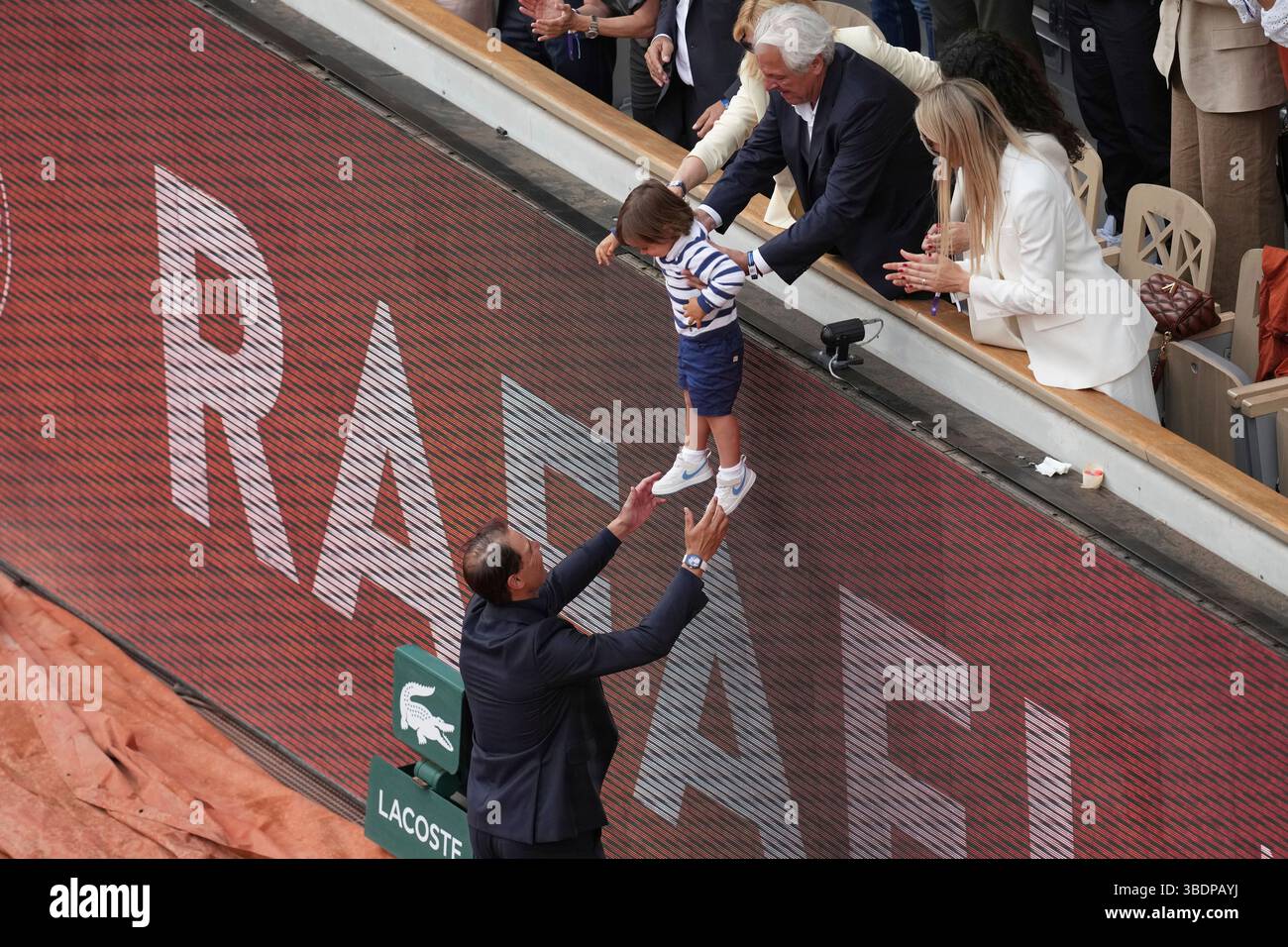 Rafa Nadal reaches for his son Rafael Junior during a farewell ceremony at center court Philippe-Chatrier, at the Roland-Garros stadium, in Paris, Sunday May 25, 2025. (AP Photo/Christophe Ena) Stockfoto