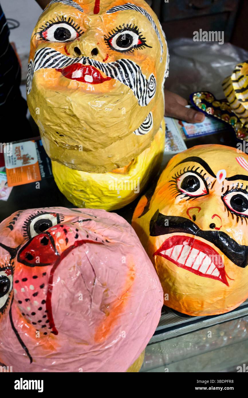 Nahaufnahme der hell bemalten Pappmasken mit mâché hinduistischen Ritualmasken, einschließlich Tigern und Dämonen, die im Shankhari Basar, Old Dhaka, Bangladesch, verkauft werden. Stockfoto