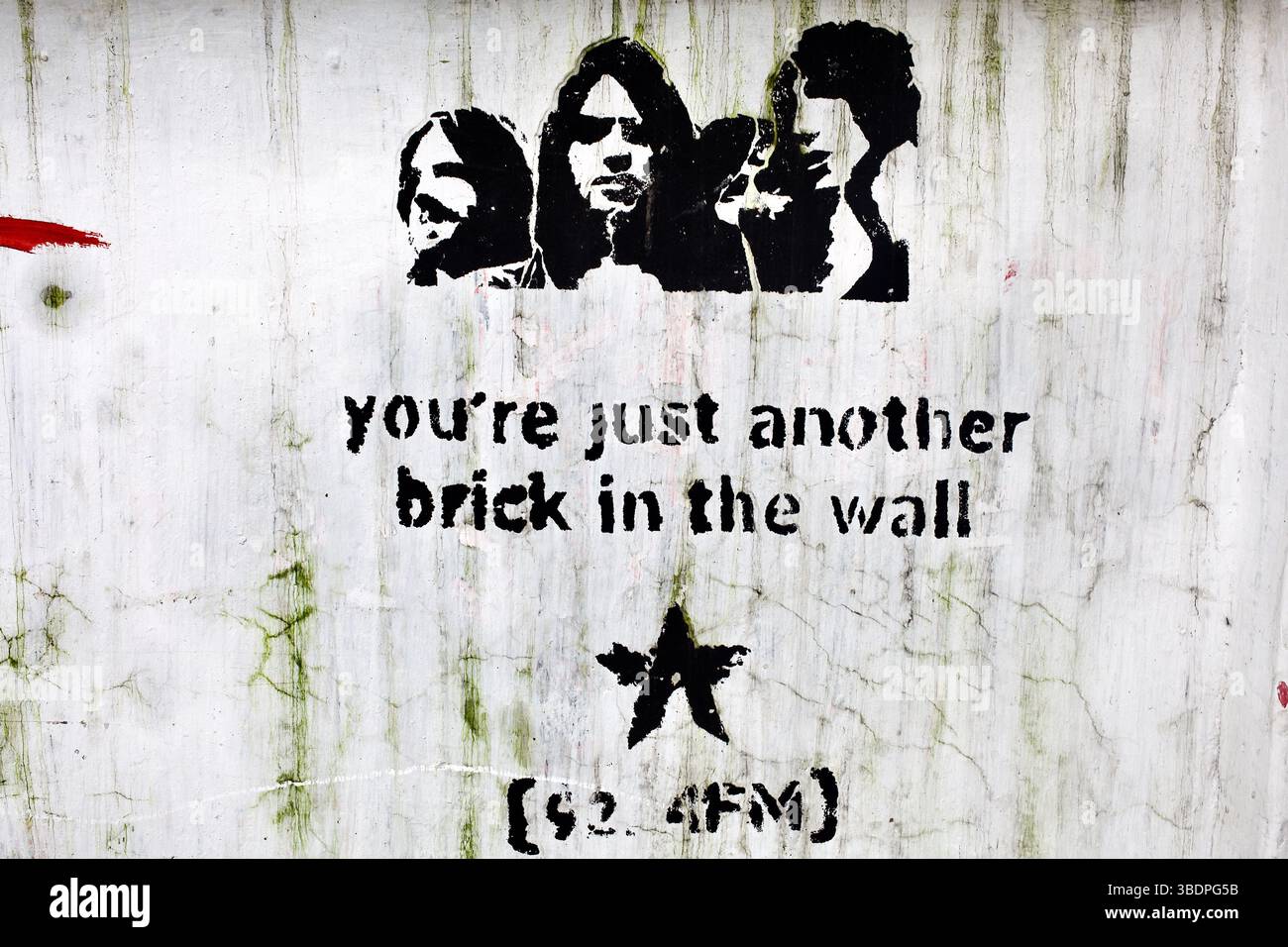 Rosafarbene Floyd-Schablone mit Text „Another Brick in the Wall“ und 92,4 FM-Logo auf einer Graffiti-Wand in Dhaka. Stockfoto