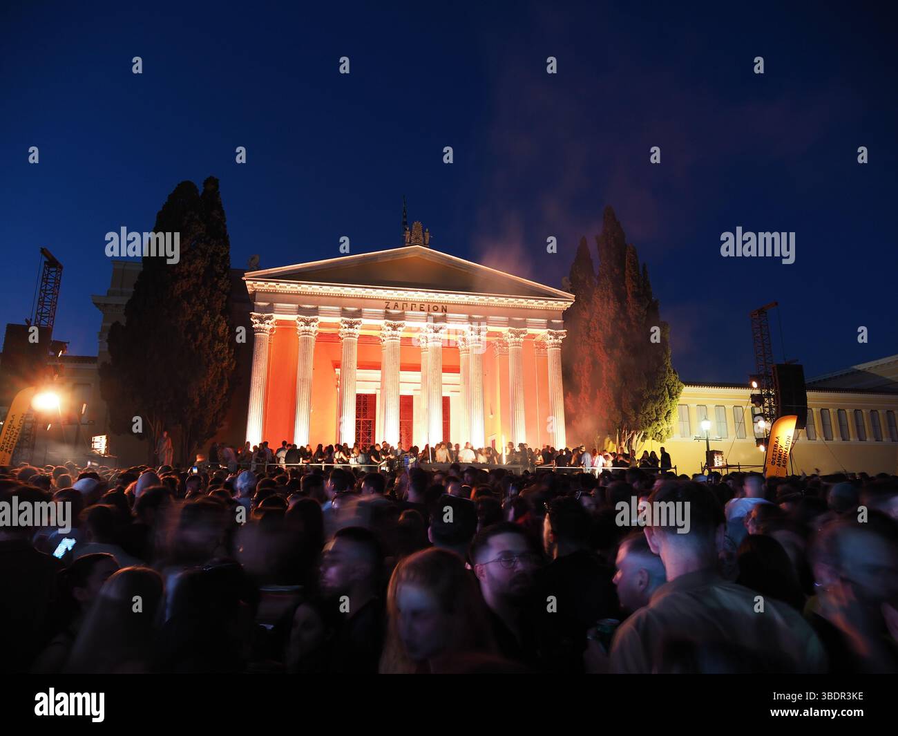 Athen, Griechenland - 3. Mai 2025: Zappeion erleuchtete nachts mit einer großen Menschenmenge, die sich vor ihnen versammelte, und sorgte für eine lebhafte Atmosphäre beim Athens City Festival 2025 Stockfoto