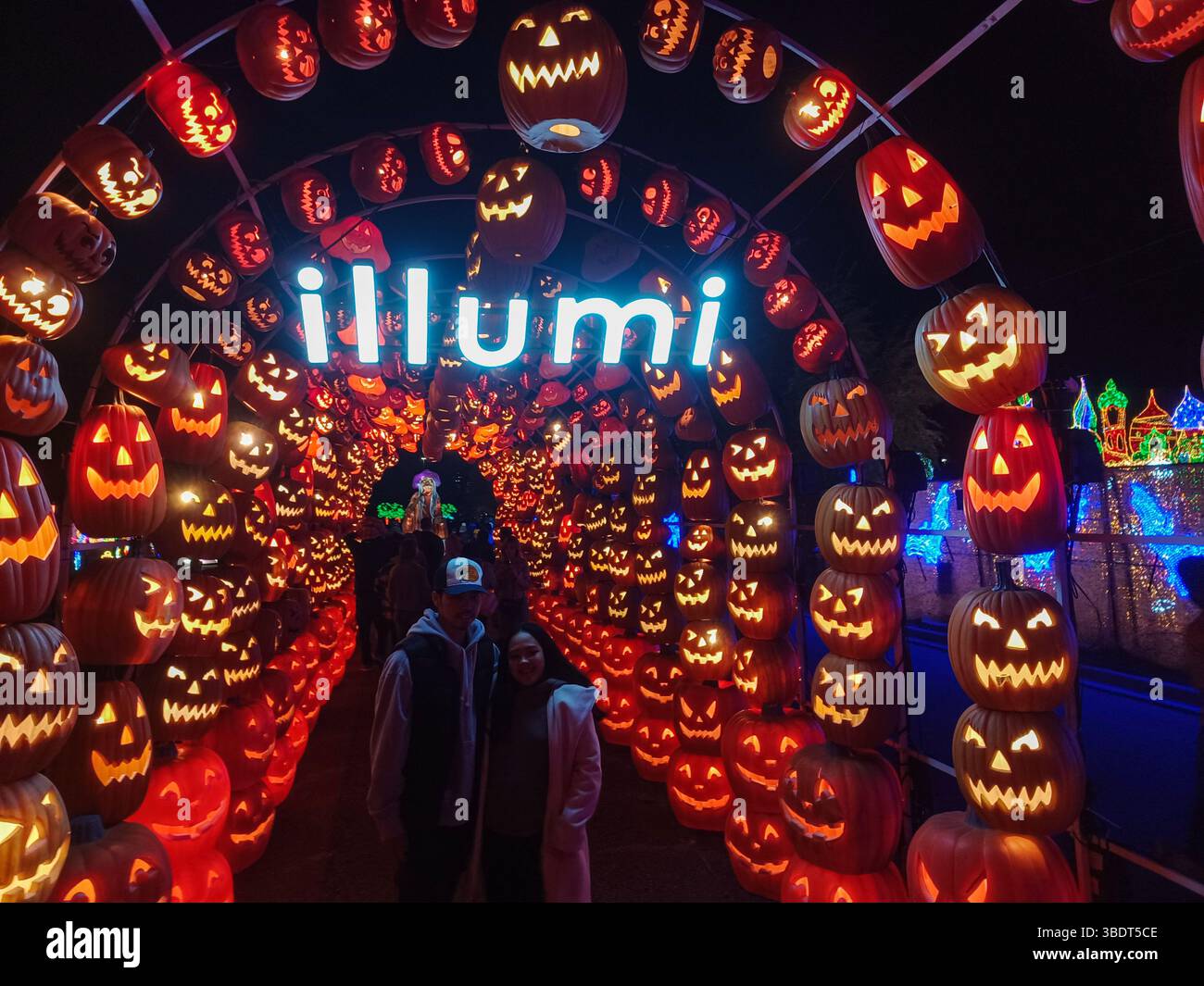 Toronto, ON, Kanada – 18. Oktober 2024: Besucher spazieren durch einen leuchtenden Kürbistunnel bei der Illumi Halloween Light Show am Abend. Stockfoto Toronto, ON, Kanada – 18. Oktober 2024: Besucher spazieren durch einen leuchtenden Kürbistunnel bei der Illumi Halloween Light Show am Abend. Stockfoto