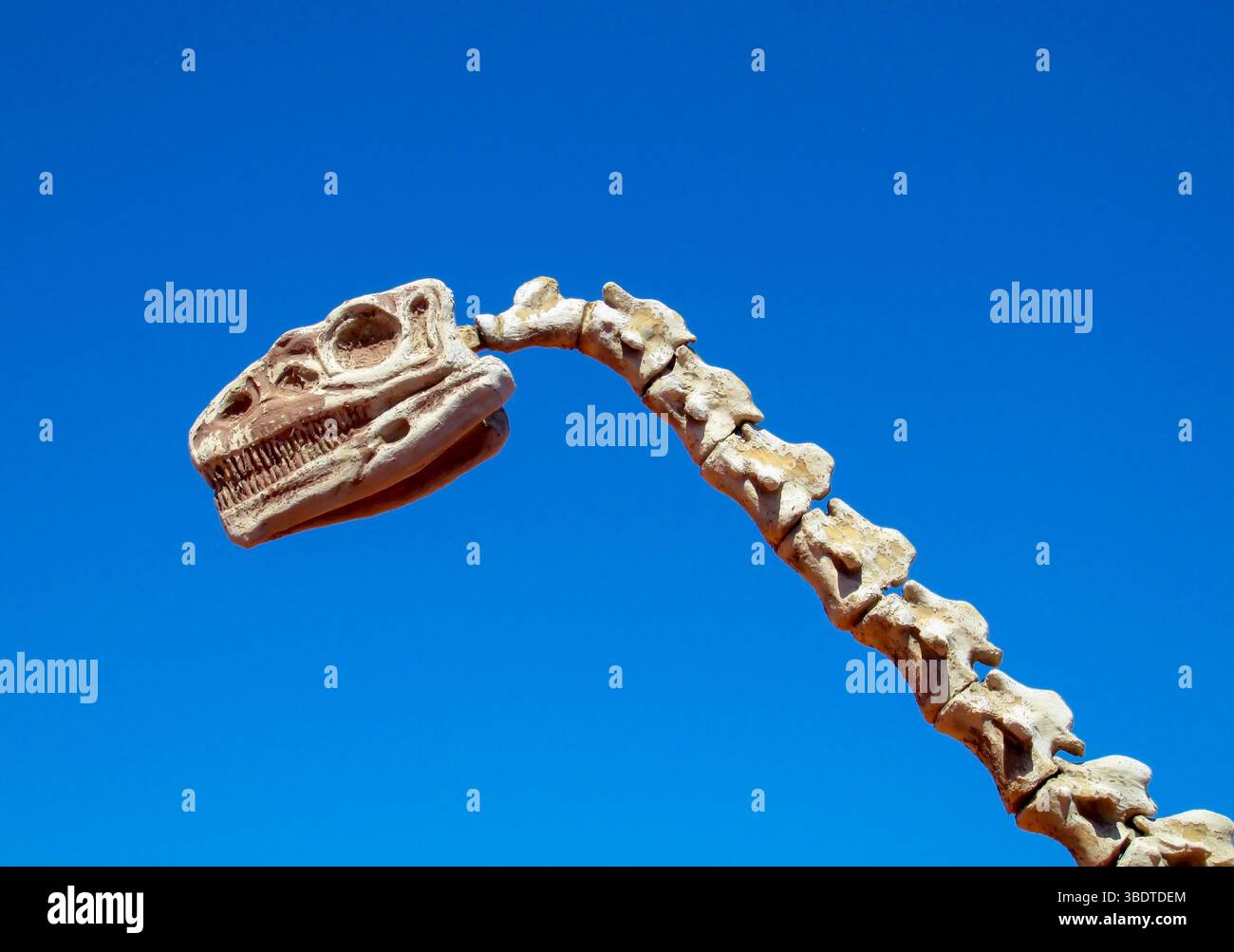 Dinosaurier im Wüstenland. Die Statue, ein Modell-Dinosaurier, der auf einem roten trockenen Sand zwischen den Felsen steht. Künstlicher Dinosaurier. Jurassic Park. Modelle Dino Stockfoto