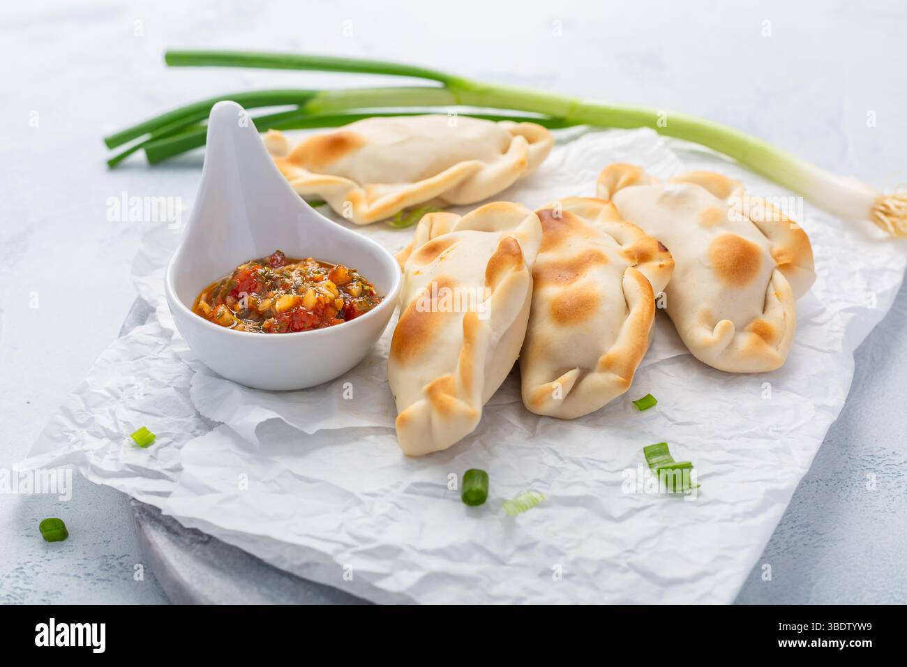 Traditionelle Empanadas mit Chimichurri-Sauce. Lateinamerikanische Küche. Stockfoto