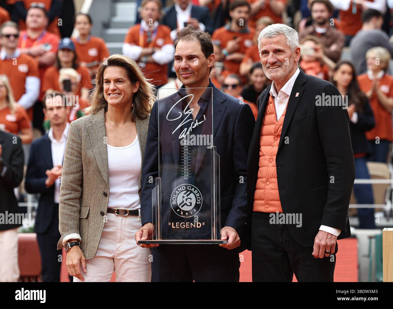 Paris, Frankreich. Mai 2025. Amelie Mauresmo (L) und der Präsident des französischen Tennisverbandes Gilles Moretton (R) überreichen eine Gedenktrophäe für den ehemaligen spanischen Tennisspieler Rafael Nadal während einer Zeremonie zu Ehren seiner Karriere während des French Open Tennis Turniers am Court Philippe Chatrier im Roland Garros in Paris, Frankreich, 25. Mai 2025. Quelle: Li Jing/Xinhua/Alamy Live News Stockfoto