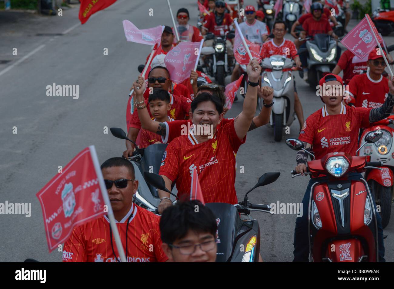 Mae Sot, Thailand. Mai 2025. Fans des FC Liverpool fahren Motorräder und Motorroller durch die Straßen von Mae SOT, schwenken Flaggen und feiern den Titelgewinn ihrer Mannschaft in der Premier League. Am 25. Mai 2025 hielten in Mae SOT, Thailand, rund 150 begeisterte Fans des Liverpool FC eine lebhafte Siegesparade durch die Stadt ab, um den Titelgewinn der Premier League zu feiern. In einem lebhaften Konvoi von Autos und Motorrädern umkreisten die Fans die Stadt und schwenkten Liverpool-Flaggen und würdigten stolz die triumphale Saison 2024-2025. Quelle: SOPA Images Limited/Alamy Live News Stockfoto