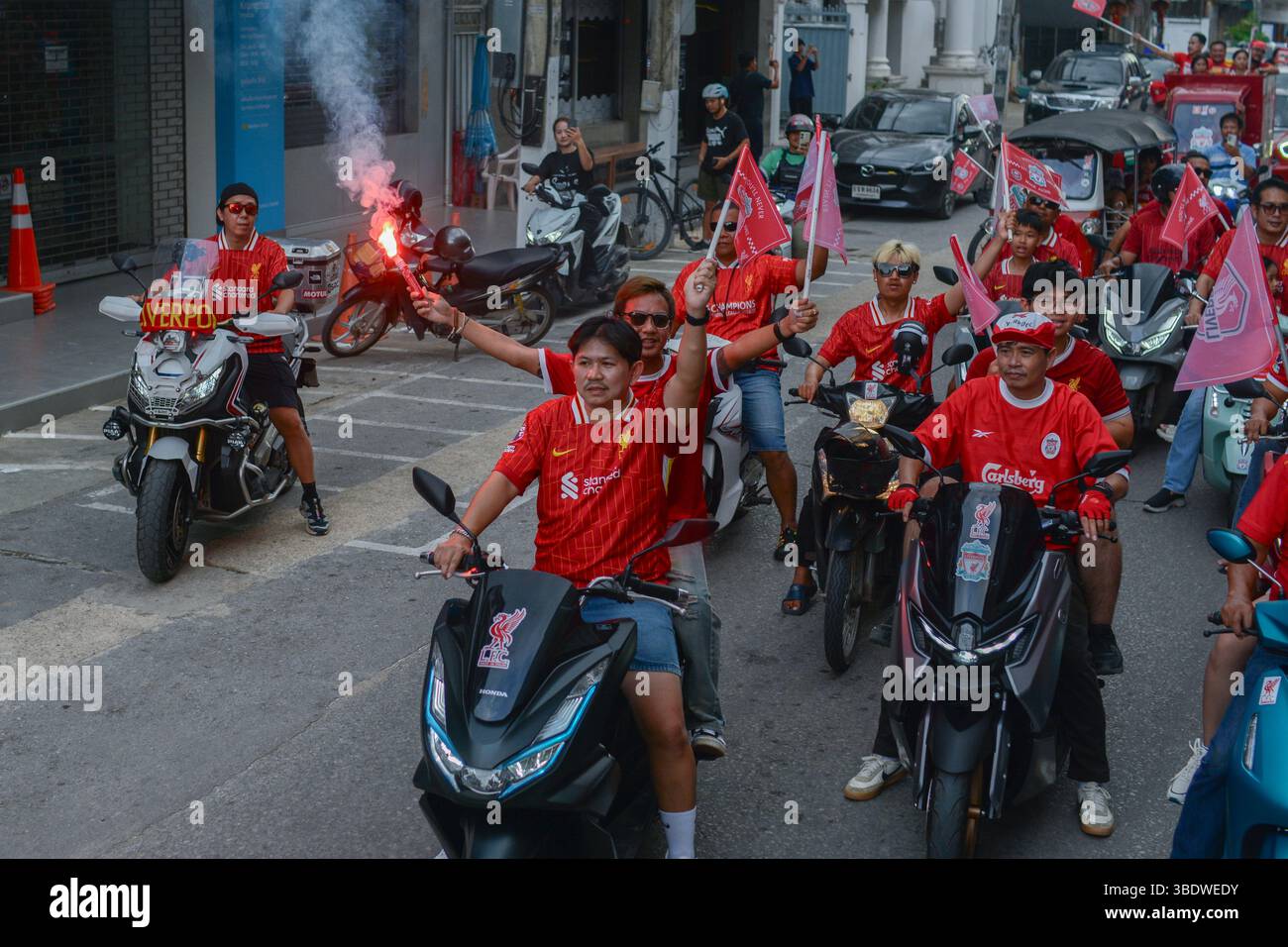 Mae Sot, Thailand. Mai 2025. Fans des FC Liverpool fahren Motorräder und Motorroller durch die Straßen von Mae SOT, schwenken Flaggen und feiern den Titelgewinn ihrer Mannschaft in der Premier League. Am 25. Mai 2025 hielten in Mae SOT, Thailand, rund 150 begeisterte Fans des Liverpool FC eine lebhafte Siegesparade durch die Stadt ab, um den Titelgewinn der Premier League zu feiern. In einem lebhaften Konvoi von Autos und Motorrädern umkreisten die Fans die Stadt und schwenkten Liverpool-Flaggen und würdigten stolz die triumphale Saison 2024-2025. Quelle: SOPA Images Limited/Alamy Live News Stockfoto