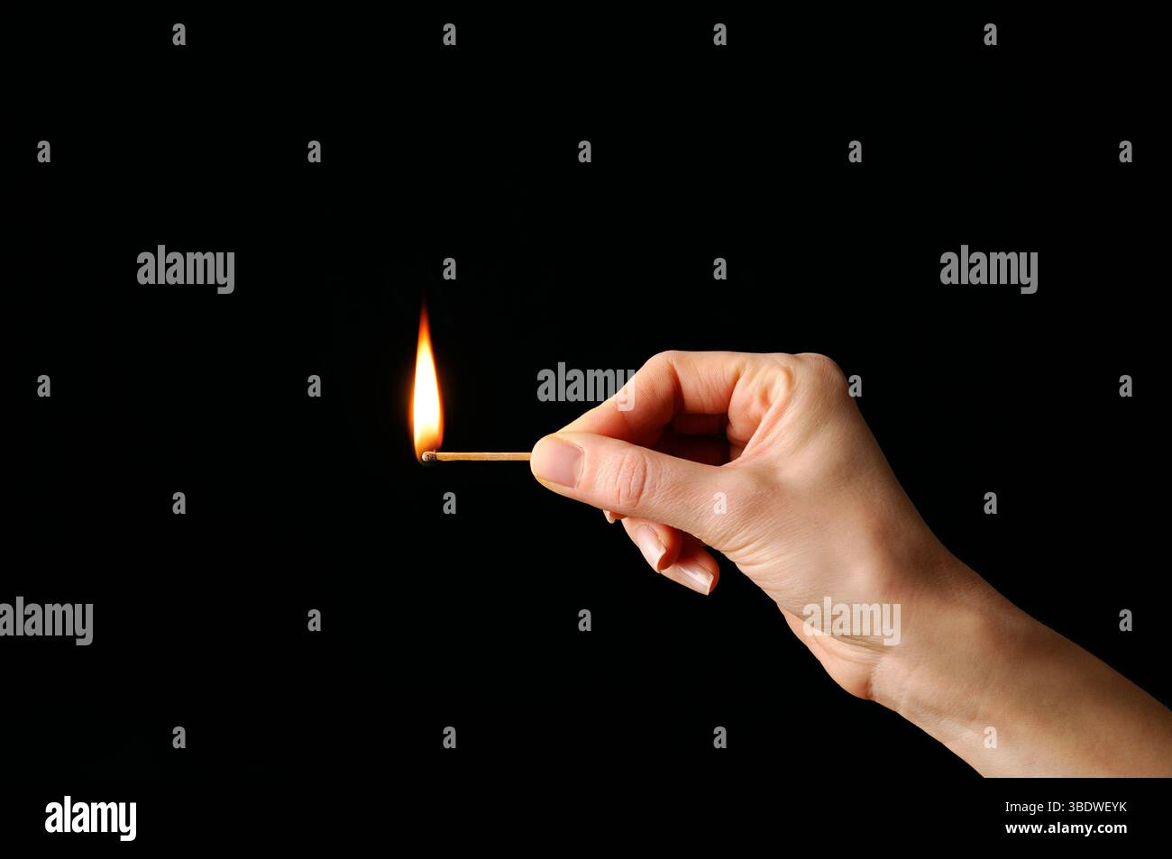 Beleuchtete Übereinstimmung vor schwarzem Hintergrund Stockfoto