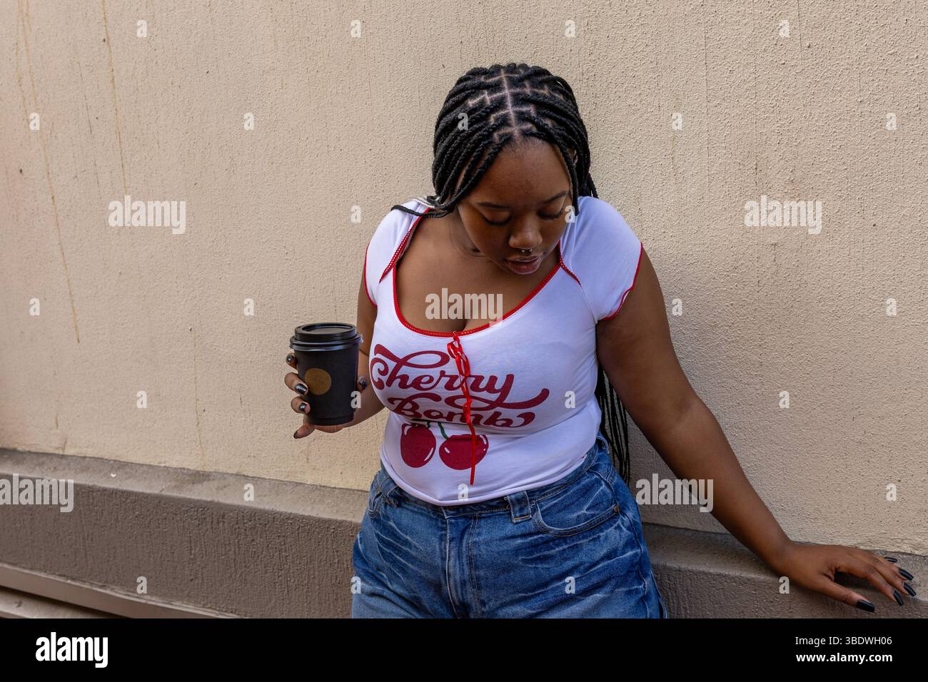 Junge schwarze Frau mit Kaffee in der Hand Stockfoto