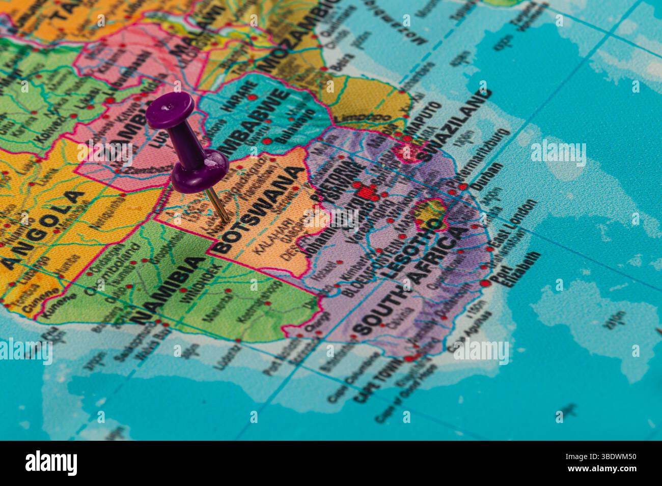 Eine helle Karte Afrikas zeigt verschiedene Länder mit einer violetten Pin, die Botswana markiert und die geografischen Details der Region betont. Stockfoto