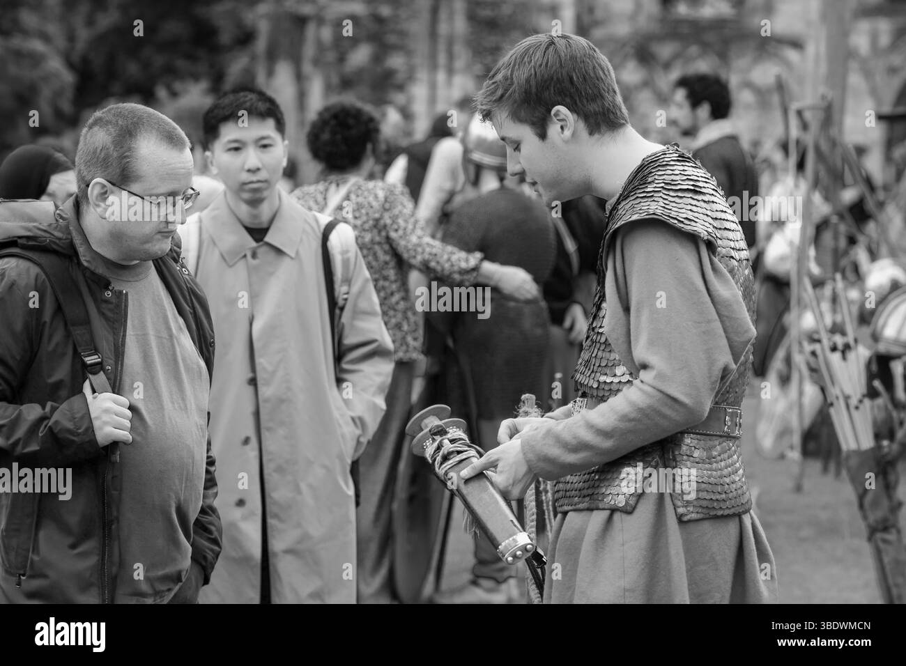 Ein römischer Reenactor teilt mittelalterliche Schwertdetails mit neugierigen Besuchern aus York, Yorkshire, Großbritannien. Stockfoto