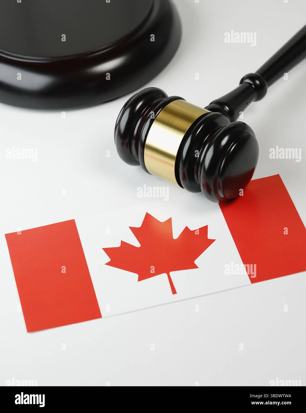Kanadisches Recht, Rechtssystem und Justizkonzept mit einem hölzernen Richter-Hamel und der kanadischen Flagge auf einem weißen Schreibtisch. Stockfoto