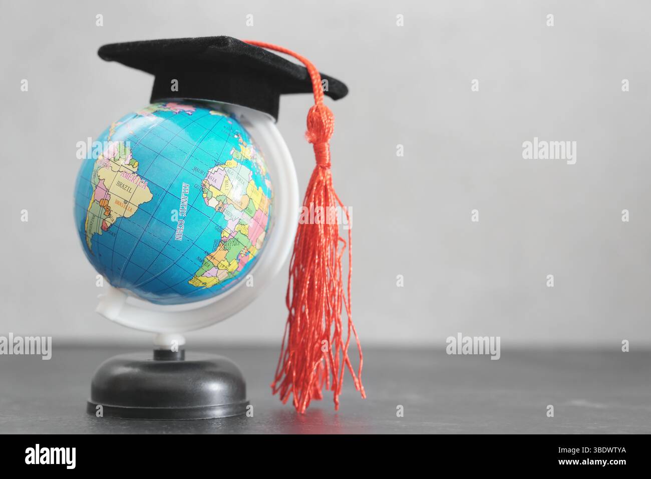 Internationaler Tag der Bildung, Auslandsstudium und globales Bildungskonzept mit Abschlusshut auf einer Erdkugel. Stockfoto