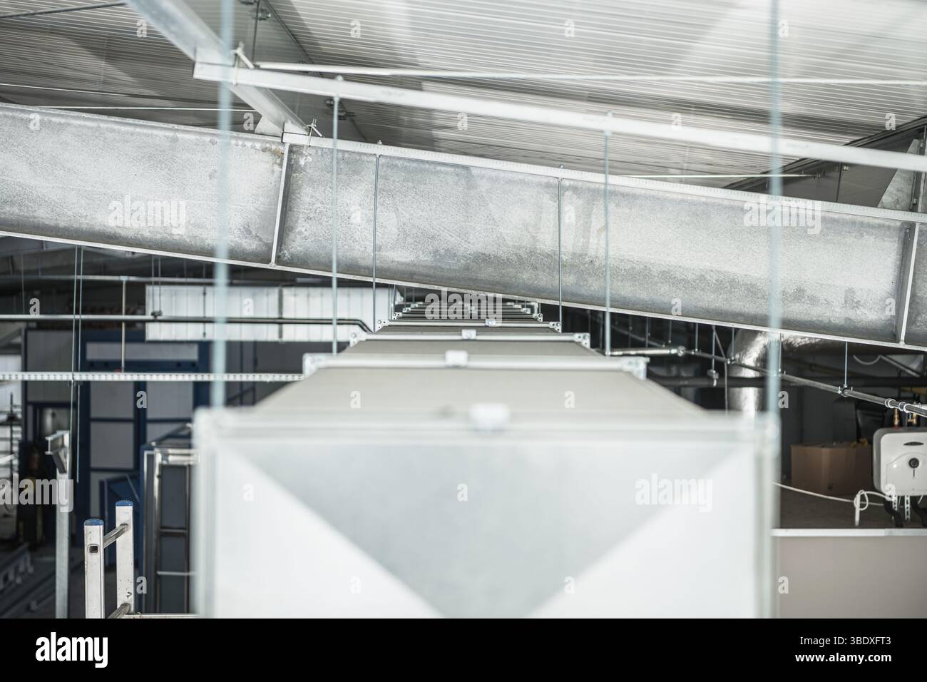 Ein genauer Blick auf Metallkanäle und Lagereinheiten in einer Industrieanlage, die modernes Design und effizientes Layout widerspiegeln, das für die Fertigungsumgebung typisch ist Stockfoto