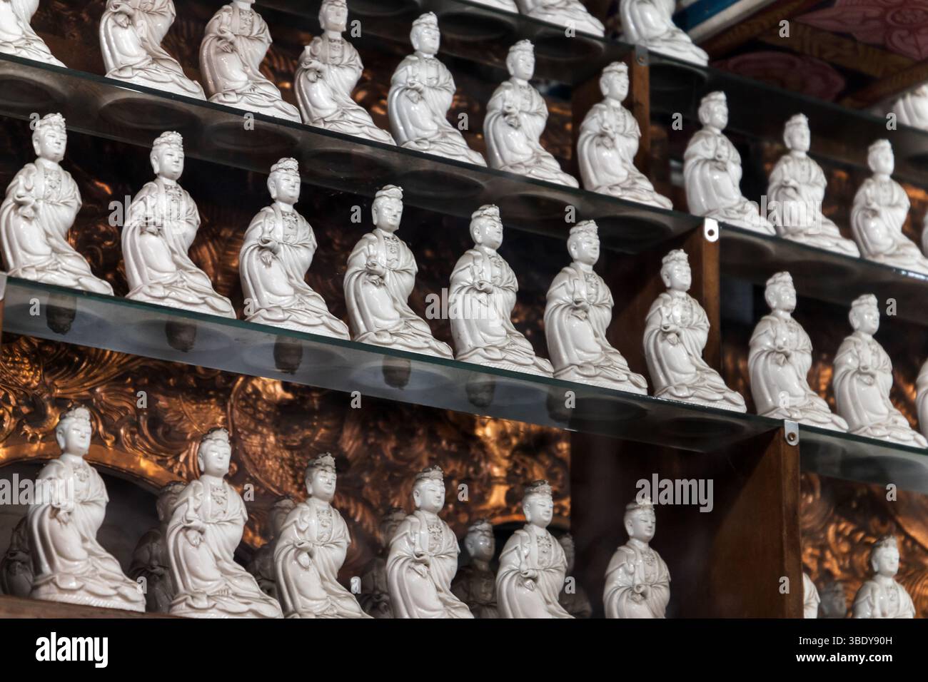 Gangaramaya Tempel, Colombo, Sri Lanka. Reihen von aufwendig gefertigten Keramikfiguren, die spirituelle Formen darstellen, in Regalen in einem Detail angeordnet Stockfoto