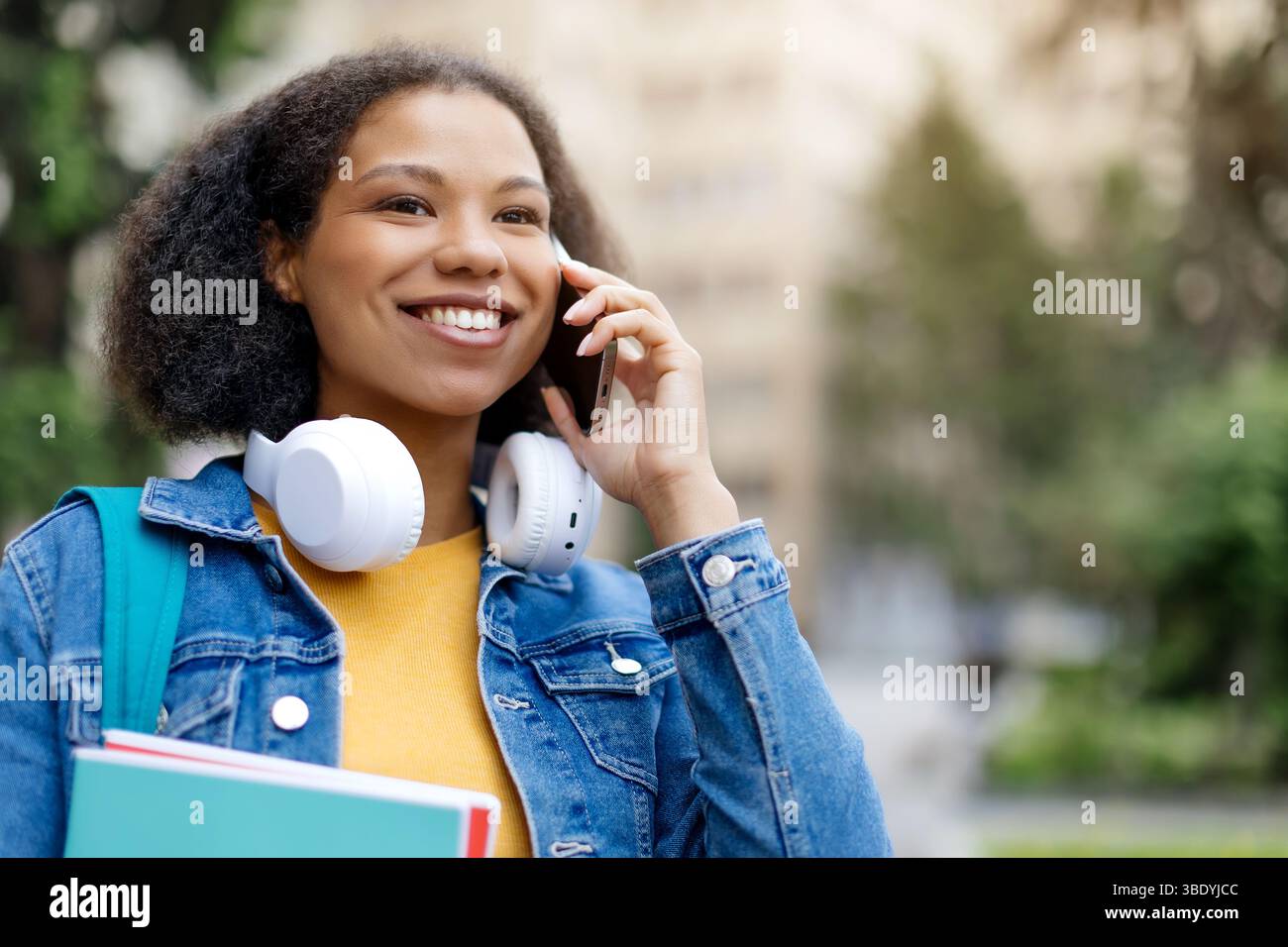 Nahaufnahme Porträt einer fröhlichen afroamerikanischen Studentin, die am Handy spricht Stockfoto