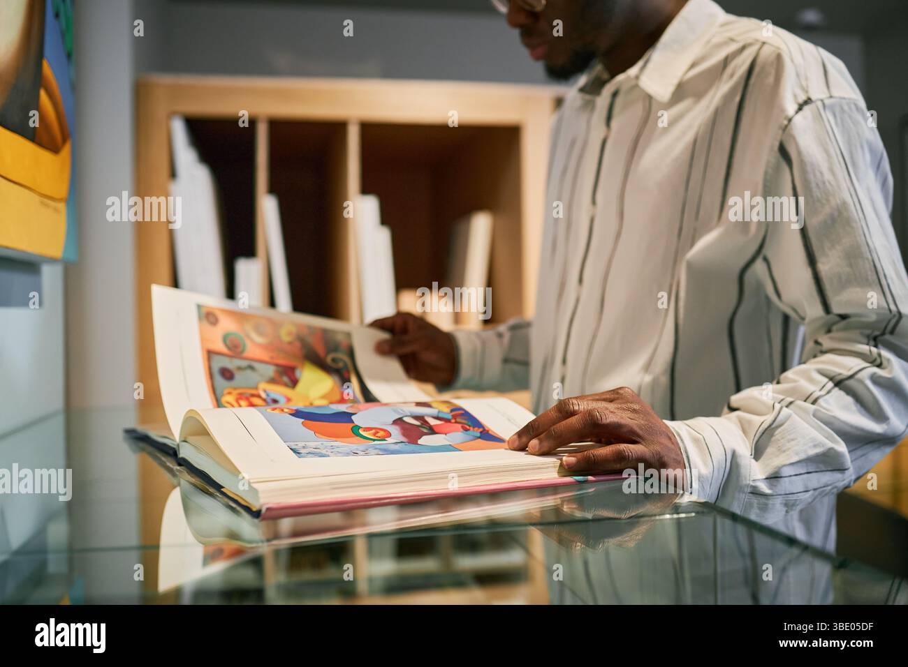 Ein Mann liest illustriertes Buch im modernen Buchladen Stockfoto