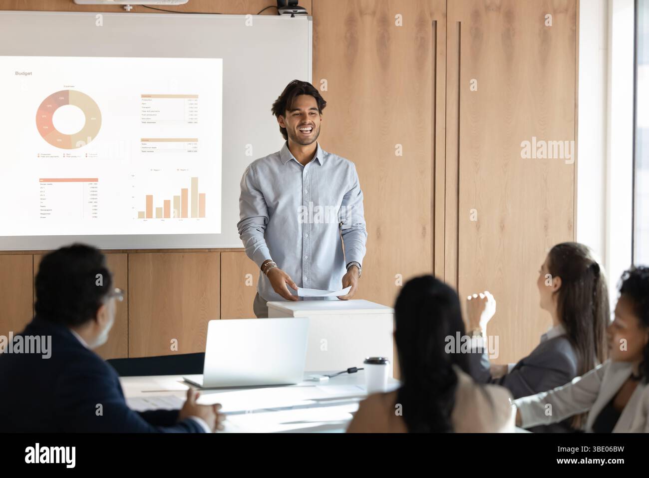 Geschäftsmann, der während des Trainings vor der Gruppe steht und spricht Stockfoto