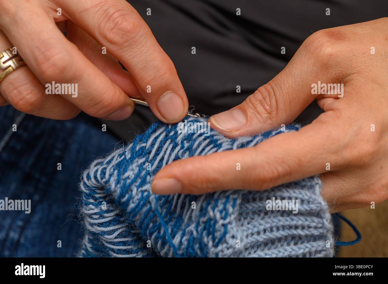 Frauenhände Stricken farbenfrohe Socken mit traditionellem Muster Stockfoto