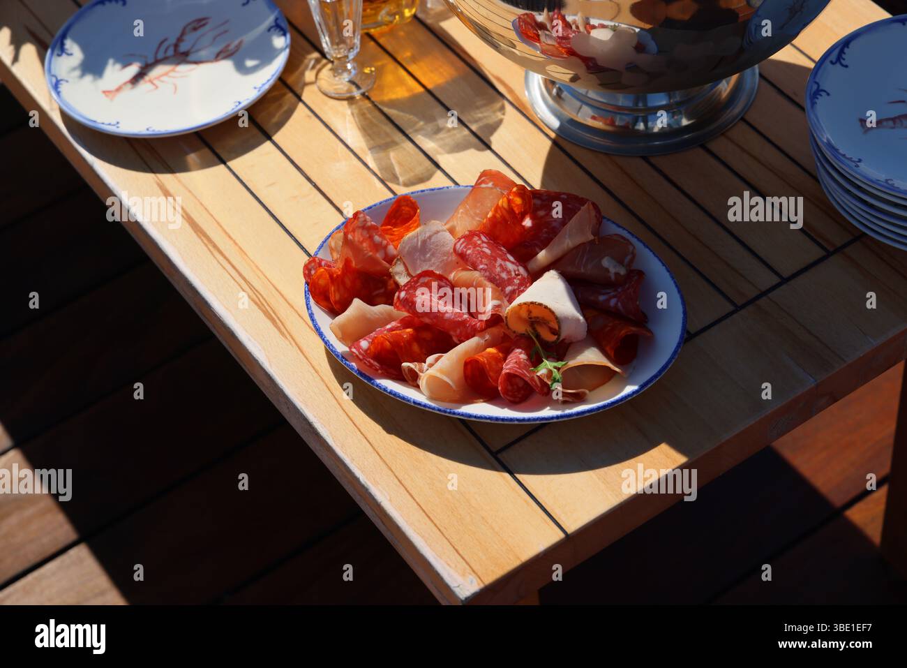 Eine wunderschön angeordnete, ausgewählte Charcuterie-Platte, die elegant auf einem Holztisch präsentiert wird Stockfoto