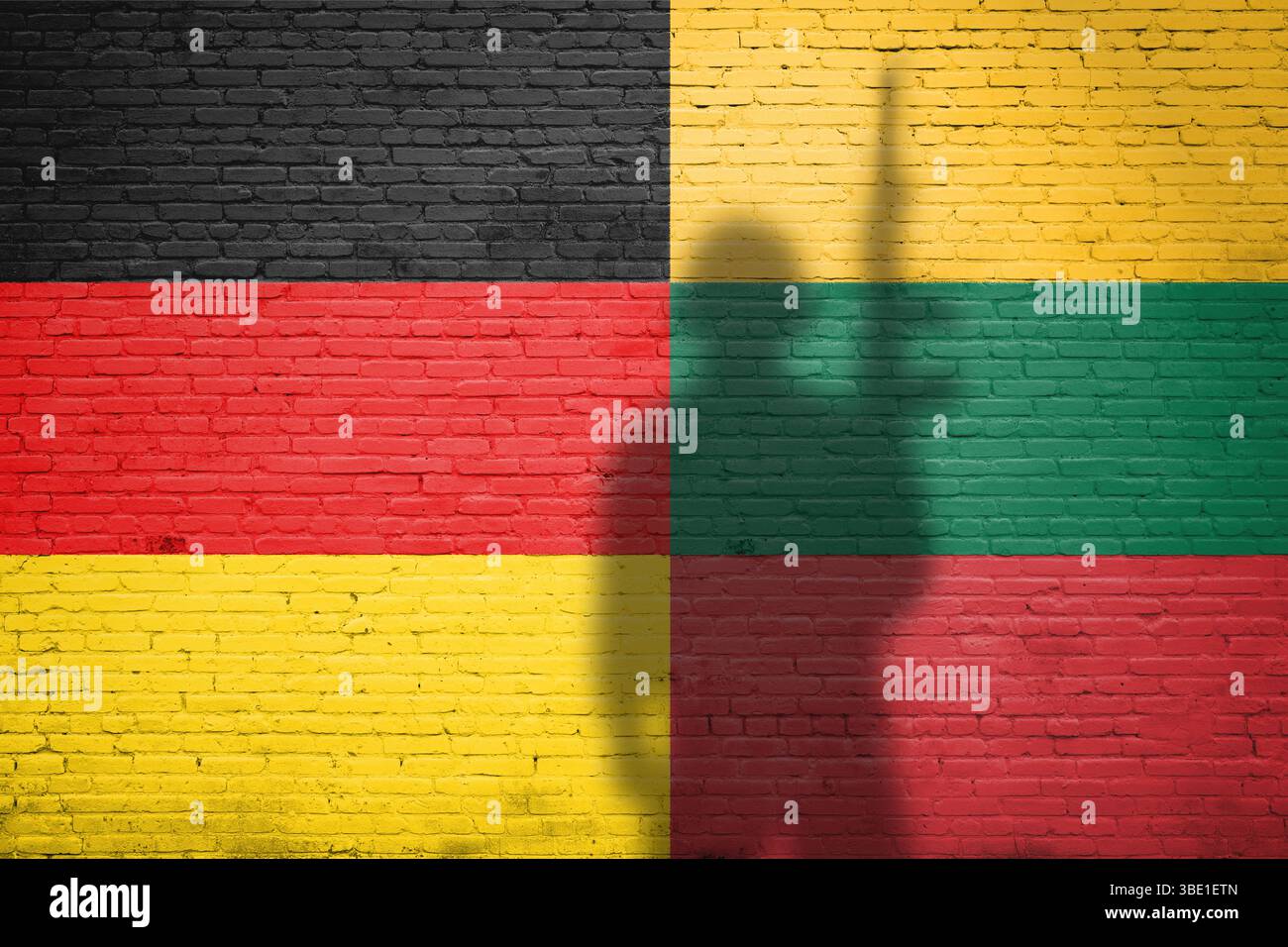 Flaggen Deutschland und Litauen gemalt auf einer Ziegelmauer mit Soldatenschatten Stockfoto
