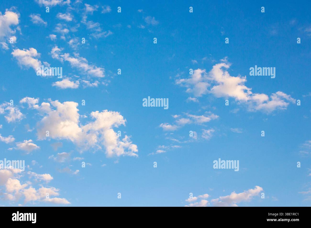 Blauer Himmel mit Wolken an einem sonnigen augustmorgen. Klimawandel. Flauschige Formationen bei hellem Wetter. Blaue Naturkulisse im Morgenlicht. Warmvorwärmung Stockfoto