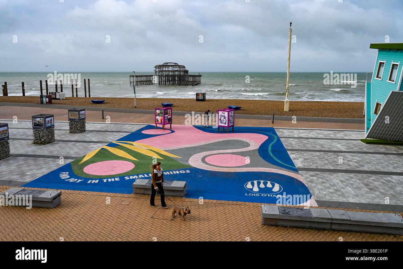 Brighton UK 27. Mai 2025 - Wanderer am frühen Morgen an einem windigen Morgen entlang der Brighton Küste, da unruhiges Wetter für Großbritannien prognostiziert wird: Credit Simon Dack / Alamy Live News Stockfoto